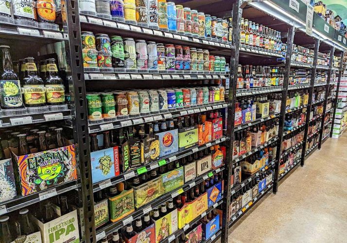 The aisles of a grocery store are full of beer. Beer distributor near