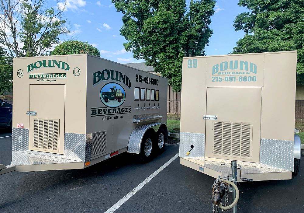 Two trailers parked in a parking lot.